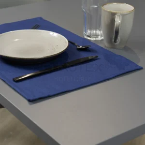 Tovaglietta idrorepellente no stiro Elite in tessuto jacquard blu con piatti e posate