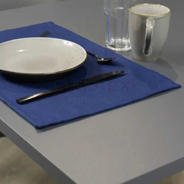 Tovaglietta idrorepellente no stiro Elite in tessuto jacquard blu con piatti e posate