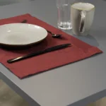 Tovaglietta idrorepellente no stiro Elite in tessuto jacquard bordeaux con piatti e posate